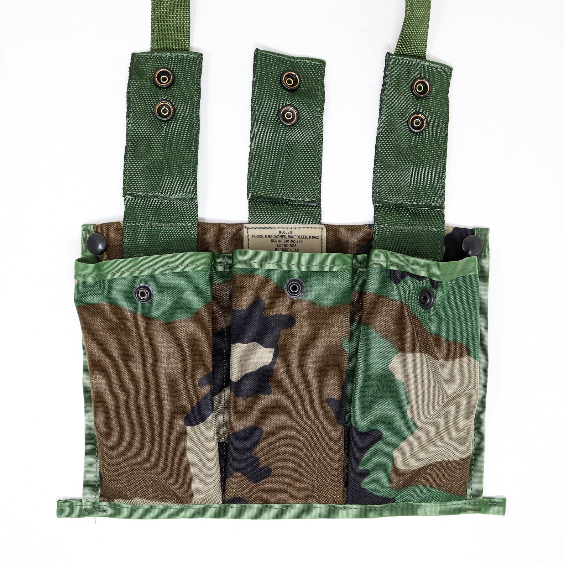 A military-style fabric pouch with three vertical pockets and three green webbing straps, shown on a plain white background. The pouch features a woodland camouflage pattern in green, brown, black, and tan.